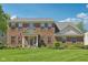 Charming two-story brick home featuring a well-manicured lawn and traditional architectural details at 14162 Nicholas Dr, Carmel, IN 46074
