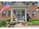 Inviting front porch with white columns, decorated with flowers and a cozy chair at 14162 Nicholas Dr, Carmel, IN 46074