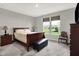 Bright bedroom features a large window offering outdoor views, complemented by neutral walls and warm wood furniture at 15004 Stonneger St, Westfield, IN 46074