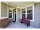 Inviting front porch featuring a wooden bench, neutral tones, and ample natural light from nearby windows at 15004 Stonneger St, Westfield, IN 46074