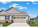 A close up shot of a garage door and home exterior details, like brick trim and landscaping at 15004 Stonneger St, Westfield, IN 46074