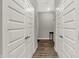 Well-lit hallway with hardwood floors, white trim, and multiple doors, creating a clean and modern aesthetic at 15004 Stonneger St, Westfield, IN 46074