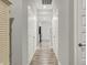 Long hallway with hardwood floors and multiple white doors, leading to different areas of the home at 15004 Stonneger St, Westfield, IN 46074
