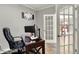 Well-lit home office space with a computer, desk, comfortable chair, and French doors leading to another room at 15004 Stonneger St, Westfield, IN 46074