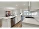 Bright kitchen features white cabinets, stainless appliances, island, and hardwood floors at 15004 Stonneger St, Westfield, IN 46074