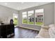 Bright living room features hardwood floors, large windows with backyard views, and a comfortable seating area at 15004 Stonneger St, Westfield, IN 46074