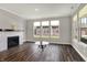 Bright living room with fireplace, large windows, and hardwood floors, showcasing a modern and inviting space at 15004 Stonneger St, Westfield, IN 46074