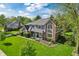 An aerial view of a charming house on a lush green lawn with mature trees around it, under a blue sky at 1508 Redwood Dr, Carmel, IN 46032