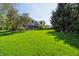 Expansive backyard featuring lush green grass, mature trees, and a patio area at 1508 Redwood Dr, Carmel, IN 46032