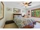 Bright bedroom featuring a ceiling fan, wood trim window, and stylish artwork and decor at 1508 Redwood Dr, Carmel, IN 46032