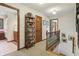 An upstairs hallway features an open staircase, carpet and wooden furniture for decor at 1508 Redwood Dr, Carmel, IN 46032