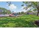 Community playground with green space and mature trees, with tennis courts and a building in the background at 1508 Redwood Dr, Carmel, IN 46032