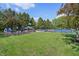 Community playground with a play structure, playhouse, and tennis courts beyond, surrounded by green space at 1508 Redwood Dr, Carmel, IN 46032