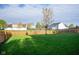 The backyard has a wood fence, grass and some small trees surrounding the property at 17060 Kingsbridge Blvd, Westfield, IN 46074