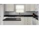 Bright kitchen features white cabinets, black countertop, and stainless steel sink at 17060 Kingsbridge Blvd, Westfield, IN 46074