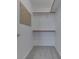 Organized walk-in closet with neutral carpeting, multiple shelves, and wooden rods for organized storage solutions at 1858 Jenny Dr, Martinsville, IN 46151