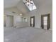 Bright living room showcasing vaulted ceilings, skylights, large windows, and neutral carpet at 1858 Jenny Dr, Martinsville, IN 46151