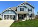 Charming two-story home featuring blue siding, stone accents, a well-manicured lawn, and an attached two-car garage at 2075 Longford Ln, Avon, IN 46123