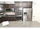 Kitchen featuring stainless steel appliances, dark cabinetry, and granite countertops at 2075 Longford Ln, Avon, IN 46123