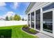 Well-maintained backyard with a screened-in porch, lush lawn, and tidy landscaping along the fence at 2250 Somerset Dr, Franklin, IN 46131