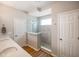 Tiled shower with a glass enclosure, a shower head, a window, and a door at 2250 Somerset Dr, Franklin, IN 46131