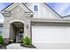 Close-up of a home entrance featuring stone accents, a two-car garage, and landscaping at 2250 Somerset Dr, Franklin, IN 46131