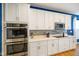 Bright kitchen features white cabinetry, stone backsplash, stainless appliances and hardwood floors at 2250 Somerset Dr, Franklin, IN 46131