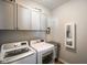 Functional laundry room with modern washer and dryer, overhead cabinets and folding area at 2250 Somerset Dr, Franklin, IN 46131