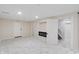 Finished basement with white walls and marble floors with a modern fireplace at 2263 N Rural St, Indianapolis, IN 46218