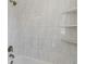 Corner tub and shower with shower head and built-in shelving in the renovated bathroom at 2263 N Rural St, Indianapolis, IN 46218