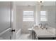 Bright bathroom with double sinks, marble tile, and frosted glass window at 2263 N Rural St, Indianapolis, IN 46218