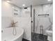 Bathroom with stylish soaker tub, shower with glass door, and marble tile at 2263 N Rural St, Indianapolis, IN 46218