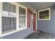 View of home entrance, with window, red shutters and storm door at 2263 N Rural St, Indianapolis, IN 46218