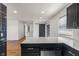 Kitchen featuring an island with marble countertop, black cabinets, and stainless steel dishwasher overlooking living space at 2263 N Rural St, Indianapolis, IN 46218