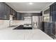 Updated kitchen showcasing marble countertops, stainless steel appliances, subway tile backsplash, and black cabinets at 2263 N Rural St, Indianapolis, IN 46218