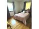 Bedroom with laminate floors, two windows, ornate bed, and matching armoire at 2402 S Rybolt Ave, Indianapolis, IN 46241