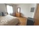 A secondary bedroom features natural light, wood floors, and standard closet at 2402 S Rybolt Ave, Indianapolis, IN 46241