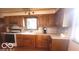 Traditional kitchen featuring wood cabinetry, laminate countertops, and natural light at 2402 S Rybolt Ave, Indianapolis, IN 46241