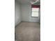 View of the bedroom with white walls, carpet, and a window dressed with a red valance at 2425 S Lyons Ave, Indianapolis, IN 46241