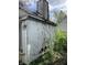 Close-up reveals extensive damage to the back of the house and overgrown foliage at 2517 Baur Dr, Indianapolis, IN 46220