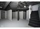 Spacious basement area featuring open ceilings, painted floors, and stairs to the upper level at 2714 N Capitol Ave, Indianapolis, IN 46208