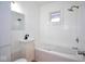 Clean, white bathroom featuring a soaking tub, tiled walls, window and vanity at 2714 N Capitol Ave, Indianapolis, IN 46208