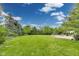 Lush backyard view showcasing a large, well-maintained lawn with mature trees and a patio area at 2979 Kings Ct, Carmel, IN 46032