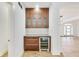 Stylish bar area with wooden cabinets, glass shelving, and a built-in wine cooler at 2979 Kings Ct, Carmel, IN 46032