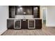 Modern basement wet bar with stylish cabinetry, stainless steel refrigerators and tile backsplash at 2979 Kings Ct, Carmel, IN 46032