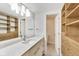Bathroom featuring a sleek countertop, modern sink, and stylish fixtures; opens to a well-organized closet space at 2979 Kings Ct, Carmel, IN 46032