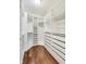 Spacious walk-in closet with custom shelving, drawers, and wood flooring at 2979 Kings Ct, Carmel, IN 46032