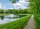 Community pond featuring a fountain and walking path in a lush green neighborhood at 2979 Kings Ct, Carmel, IN 46032