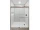 Shower featuring glass doors, modern fixtures, and subway tile, offers a clean and inviting experience at 2979 Kings Ct, Carmel, IN 46032