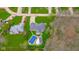 Aerial view of a well-maintained home with a large backyard, swimming pool, and surrounding greenery at 310 Edgewood E Pl, Anderson, IN 46011